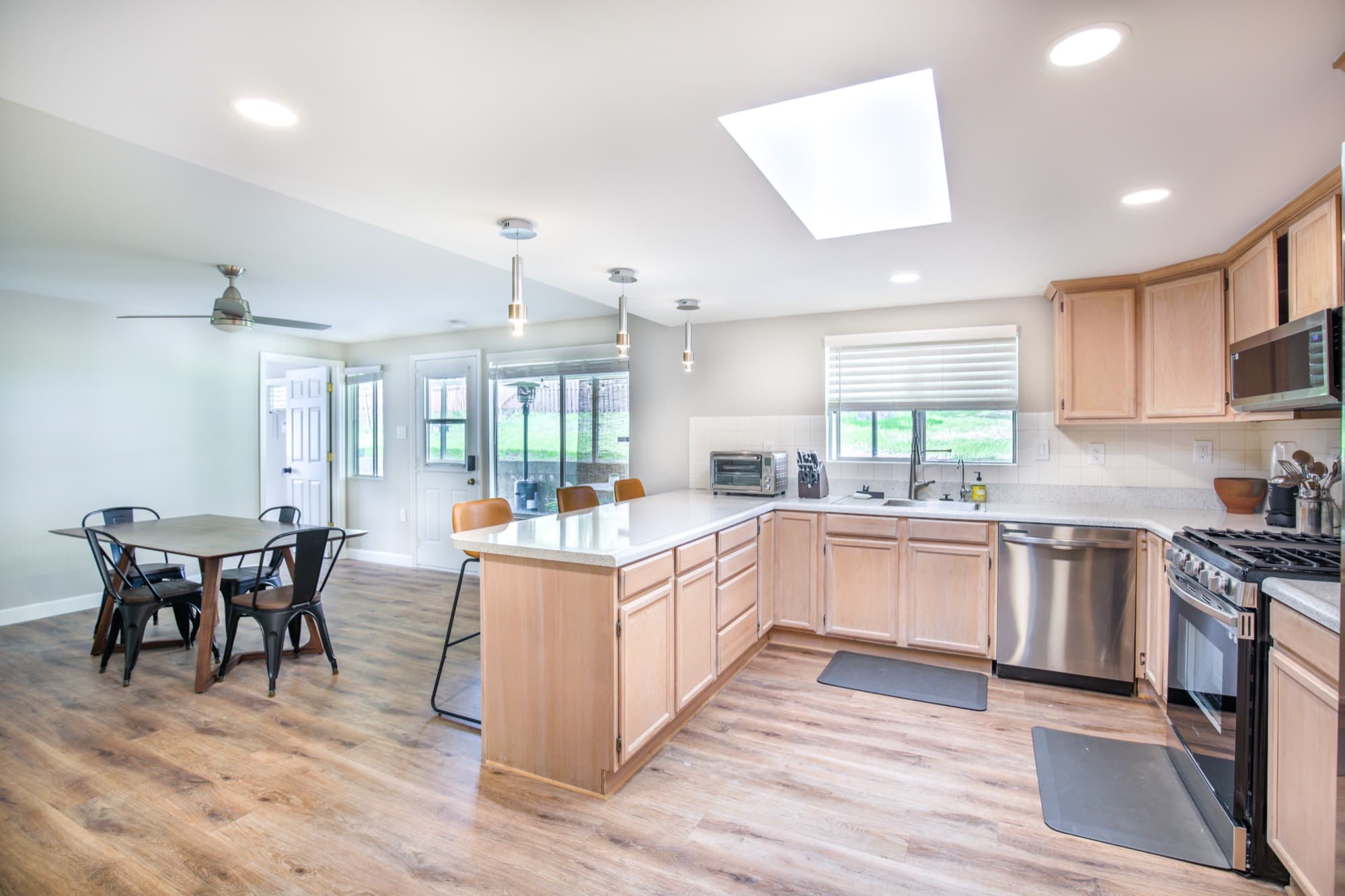 Kitchen wide view with skylight, breakfast bar, and open dining area