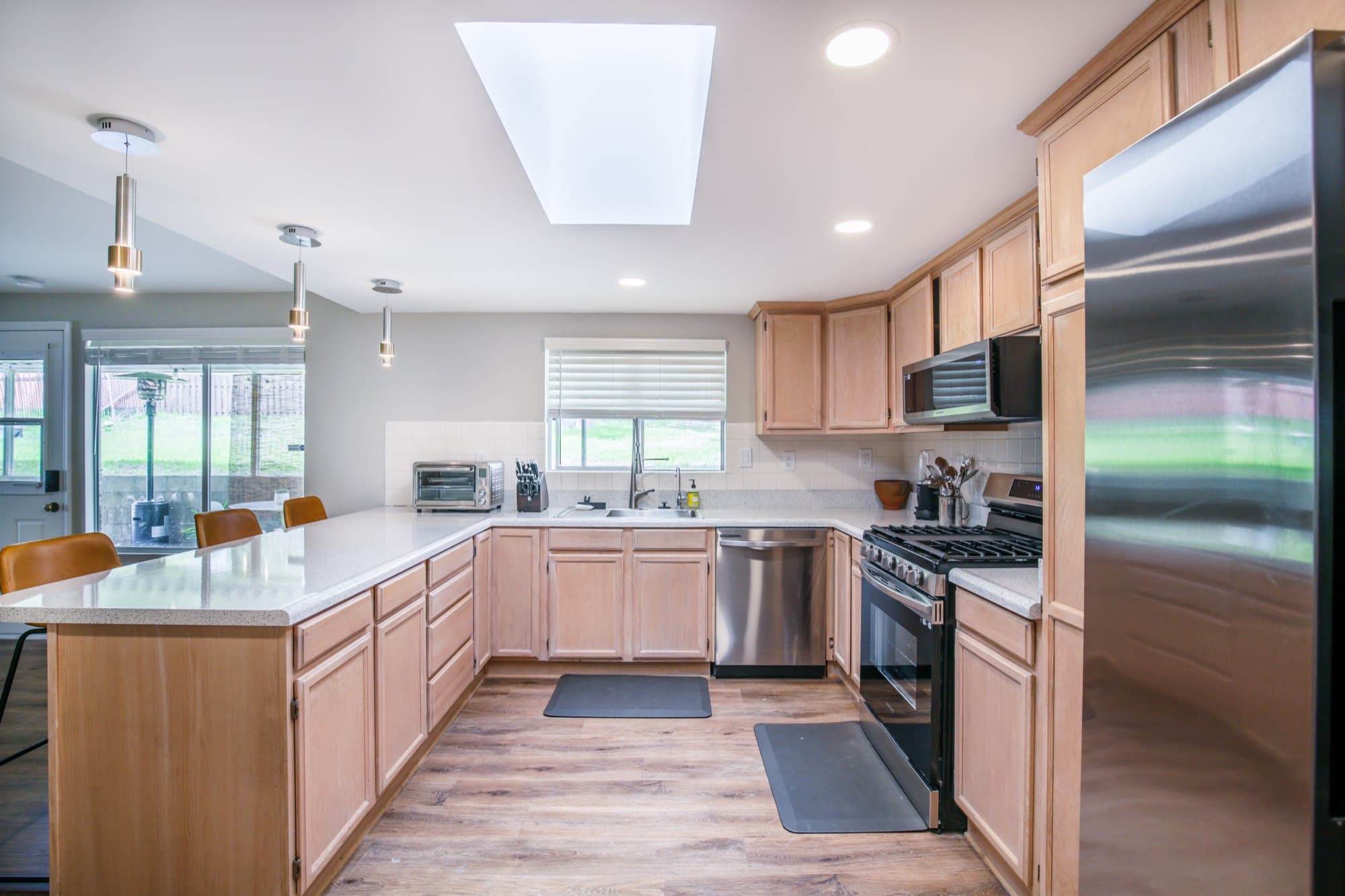 Kitchen with stainless steel appliances, skylight, and maple cabinetry