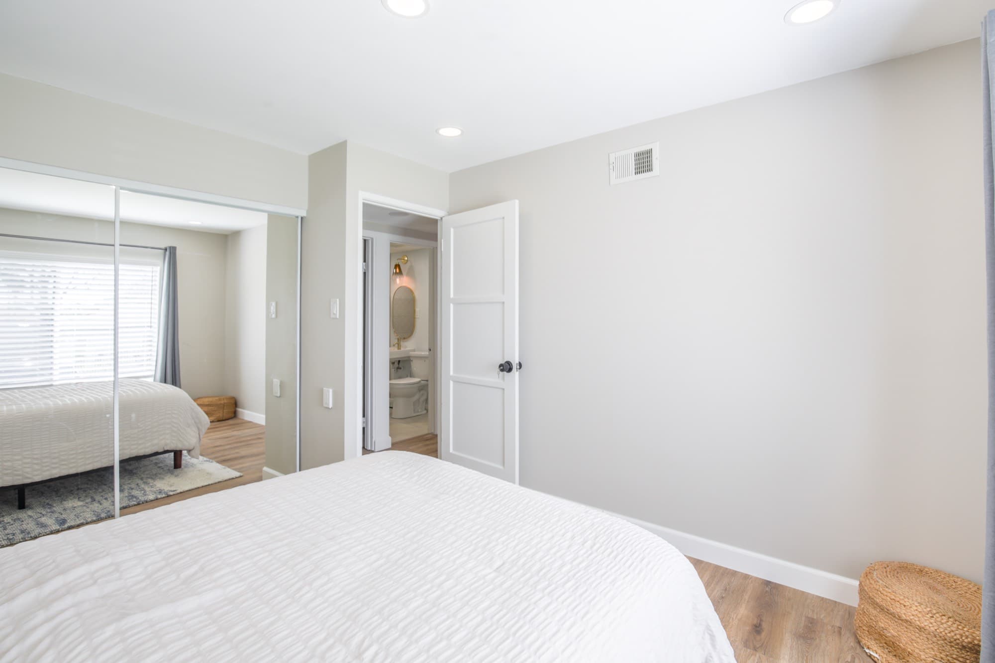 Guest bedroom with mirrored closet doors and en-suite bathroom access