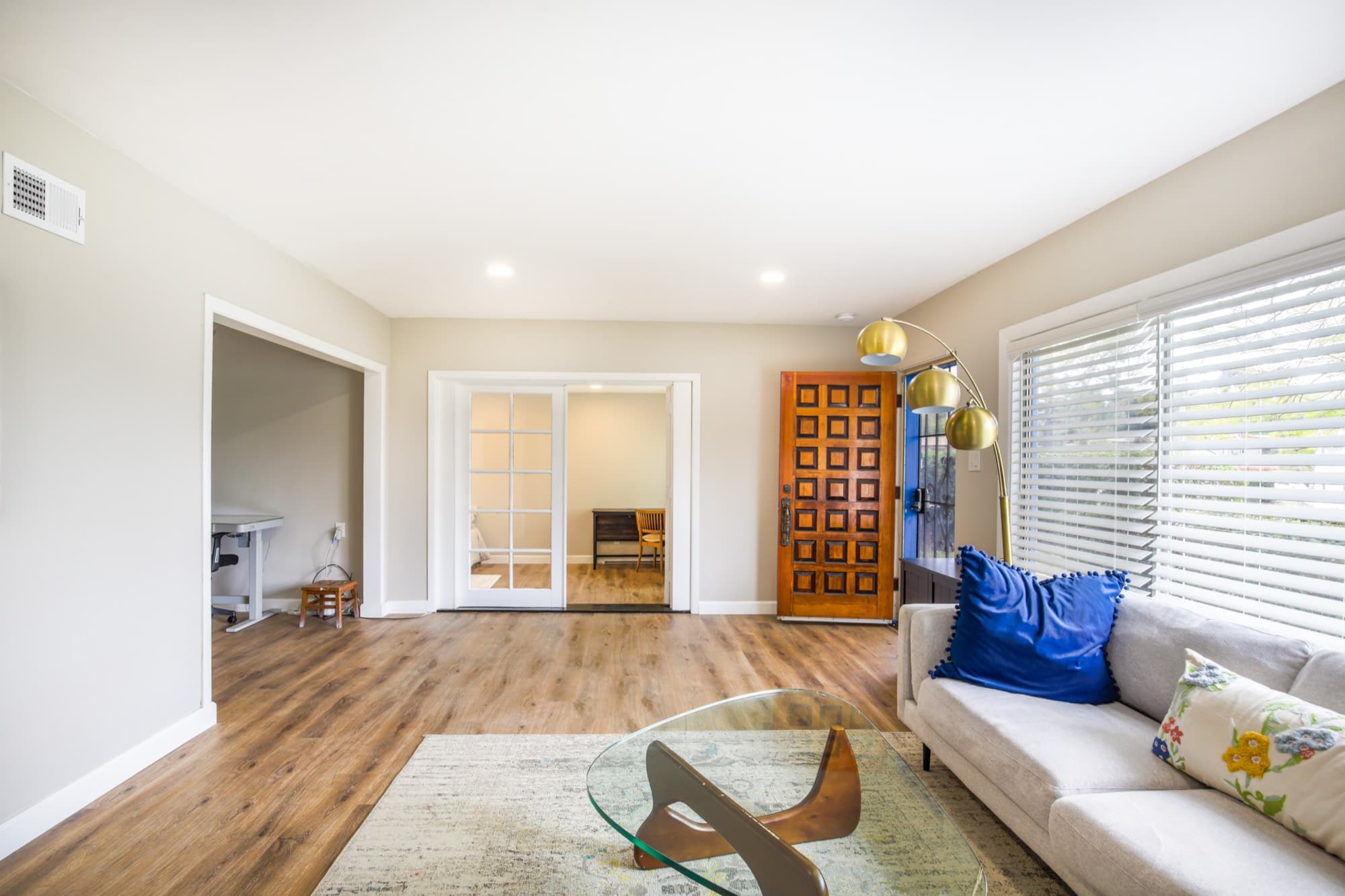 Living room with French doors to bedroom, front entry, and open floor plan